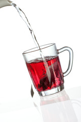 Pouring tea into transparent tea cup