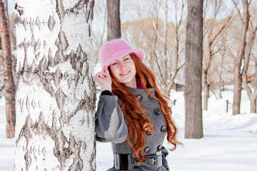woman near a birch in winter in a park