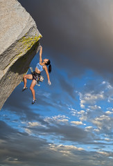 Rock climber clinging to a cliff.