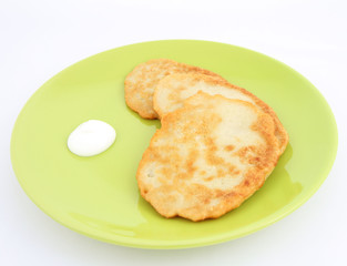 Potato pan cakes with cream on white background