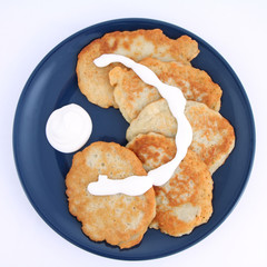 Potato pan cakes with cream and sugar on white background