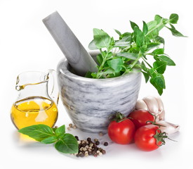 Mortar with pestle and basil herbs and olive oil.