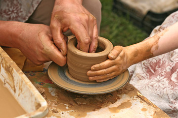 Close-up of hands making pottery on a wheel