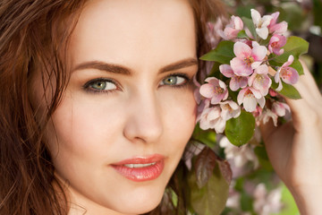 portrait of young lovely woman in spring flowers