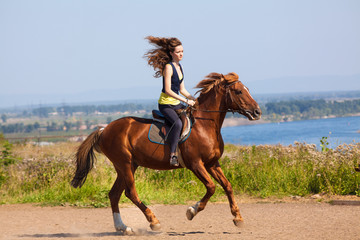 young cowgirl on brown horse