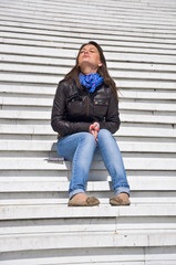 Attractive young woman sitting on the marble steps