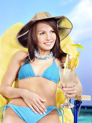 Girl in bikini drinking cocktail.