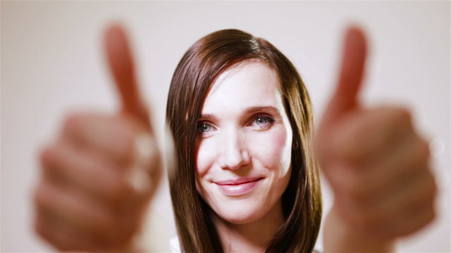 Smiling woman holding thumbs up