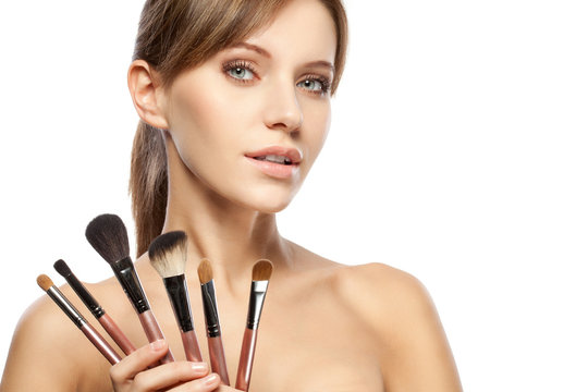 beautiful woman holding makeup brushes set