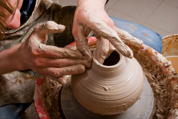 hands of a potter, creating an earthen jar on the circle