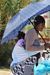 Madre africana con figlia sulle spalle