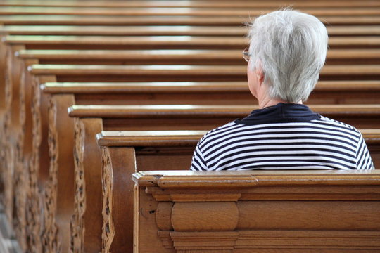Frau sitzt in Kirche