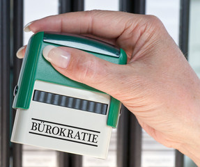 Bürokratie Stempel mit Hand im Büro