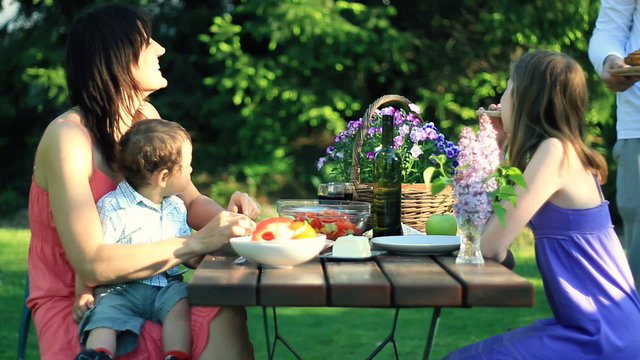 Happy family eating in the garden