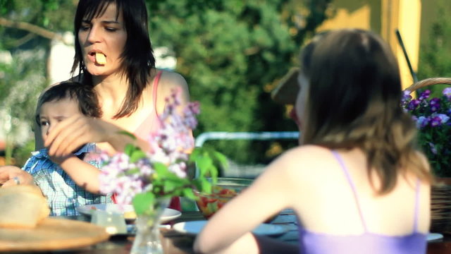 Mother with children eating in the garden, dolly shot