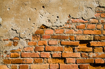 The old collapsing wall made of a red brick