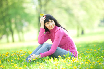 Cute woman in the park with dandelions