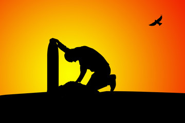 Man near the grave at sunset