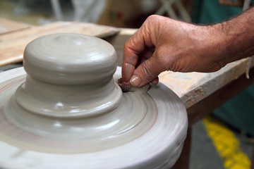 man potter hands working on pottery clay wheel