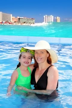 mother and daughter hug in pool tropical beach