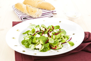 Fresh salad with bread and dressing.