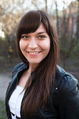 Portrait of young smiling woman a brunette with long brown hair