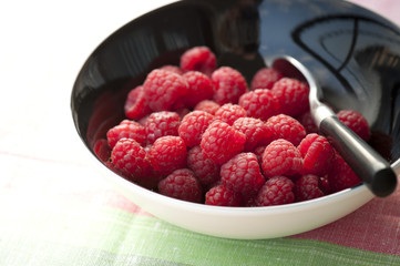 Black bowl of fresh raspberries