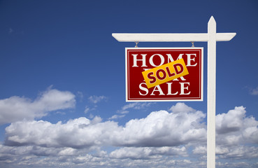 Red Sold Home For Sale Real Estate Sign Over Clouds and Sky