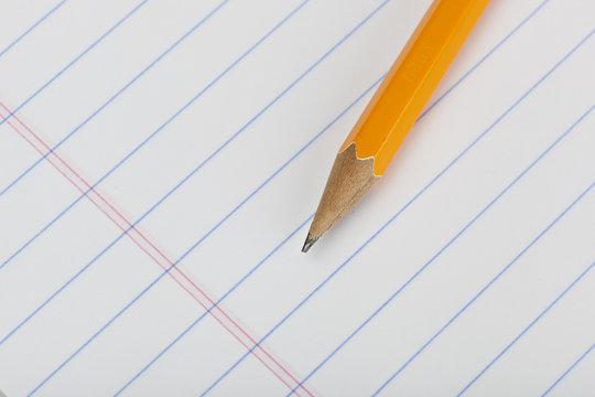 A Yellow Pencil On A Piece Of Notebook Paper