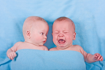 Two sweet babies - one looking, one crying