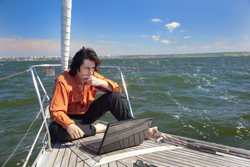 Businessman with laptop on sailboat