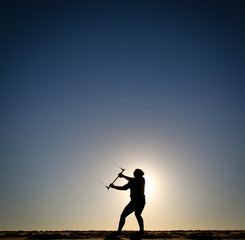 silhouette of girl flying kite at sunset