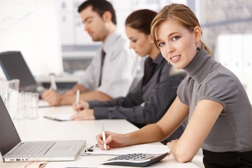 Young businesspeople sitting at meeting table