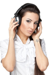 Young female listening to music in headphones isolated