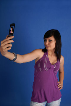 Brunette taking autoportrait using her mobile phone
