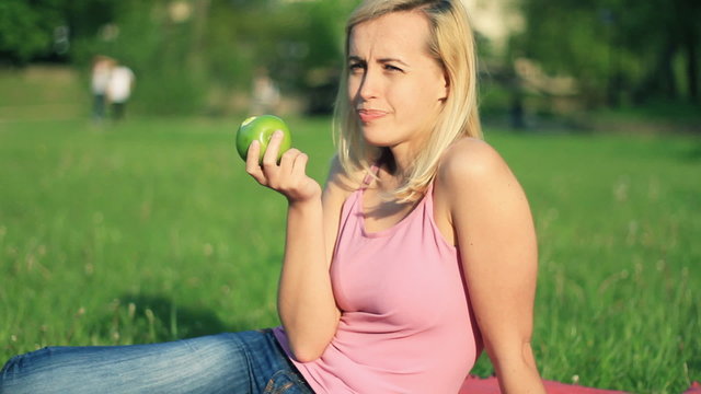 Attractive happy woman biting fresh apple outdoor
