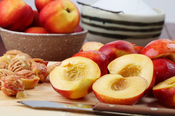 Halved nectarines on a cutting board for jam making