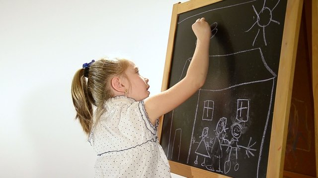 bambina disegna alla lavagna