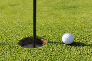 Golf ball near hole on golf course