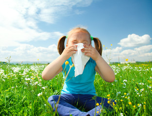 Little girl is blowing her nose