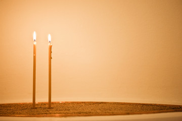 Two candles in sand