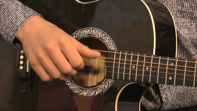 музыкант играет на гитаре в студии