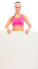 Smiling young fit girl holding blank billboard in hands