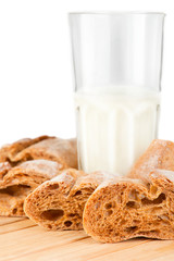 Glass of milk and fresh homemade bread on wooden table