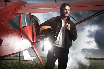 Handsome man standing in front of aeroplane © konradbak