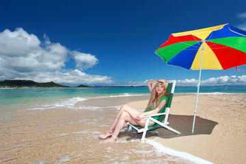 Fototapeta na wymiar 久高島のビーチで日光浴を楽しむ笑顔の女性