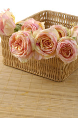 Bouquet of rose flowers in basket on mat
