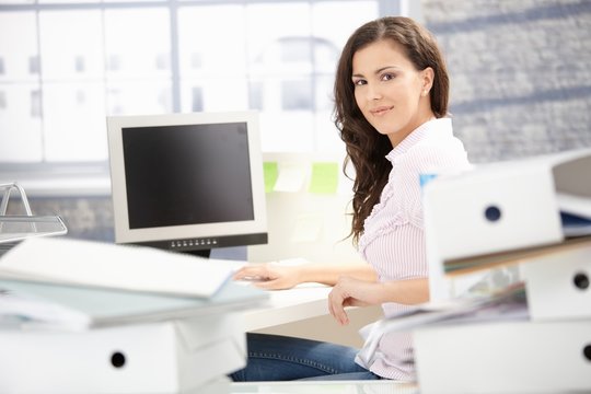 Attractive girl working in bright office smiling