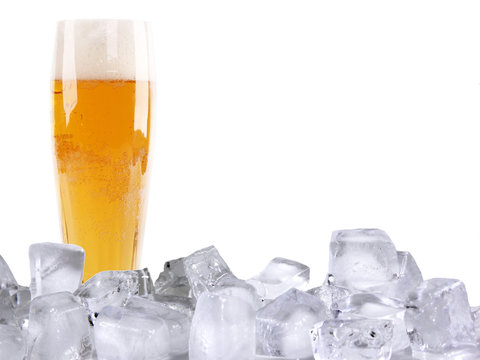 Glass of beer with ice cubes, isolated on white background