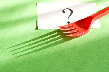 Fork and card isolated on green background